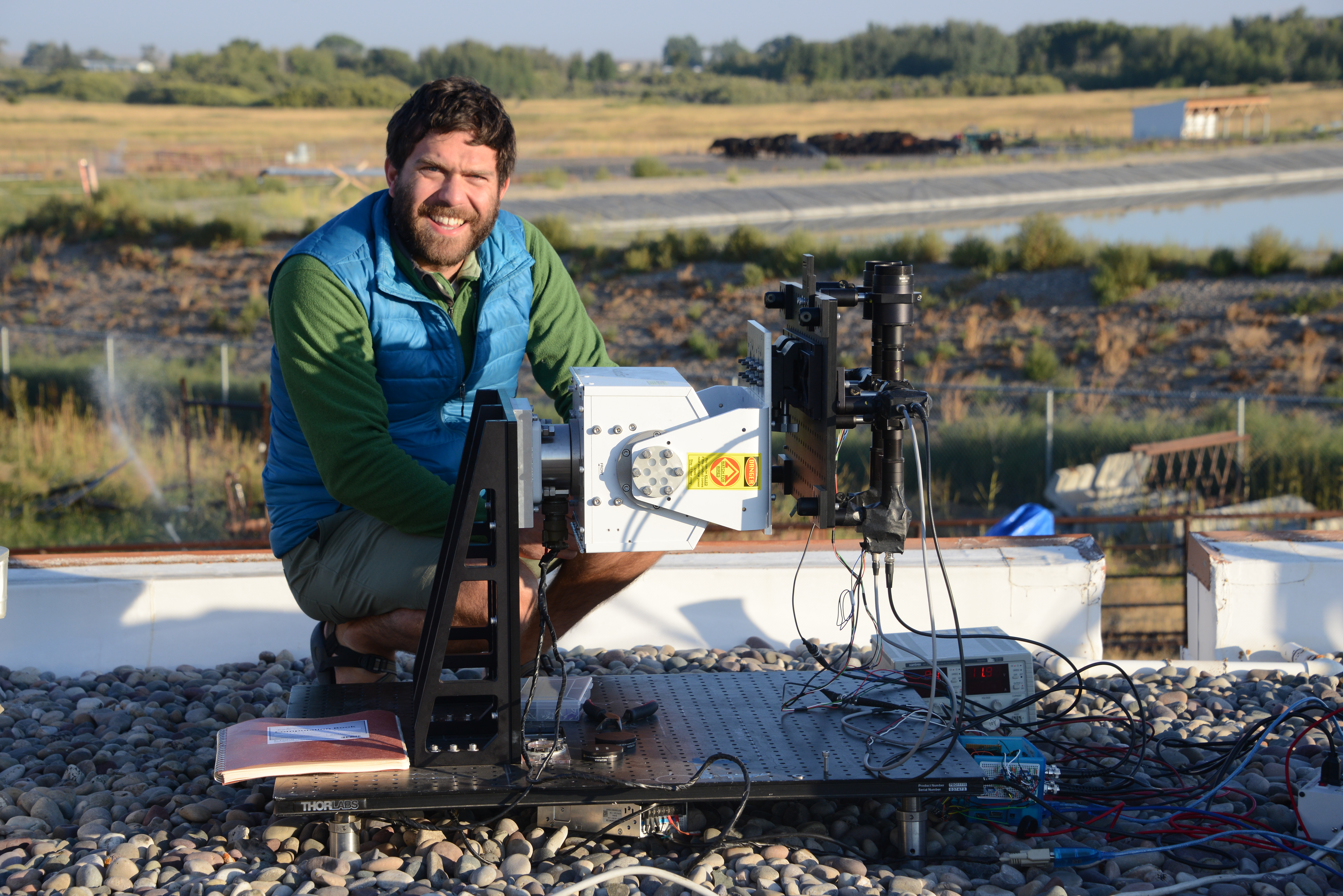 Optics graduate student preparing optical sensor at field experiment
